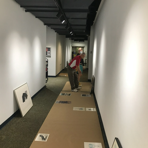 Ray Whelan and Oliver Erwich aesthetically placing mokuhanga prints at the Richard F Brush Gallery